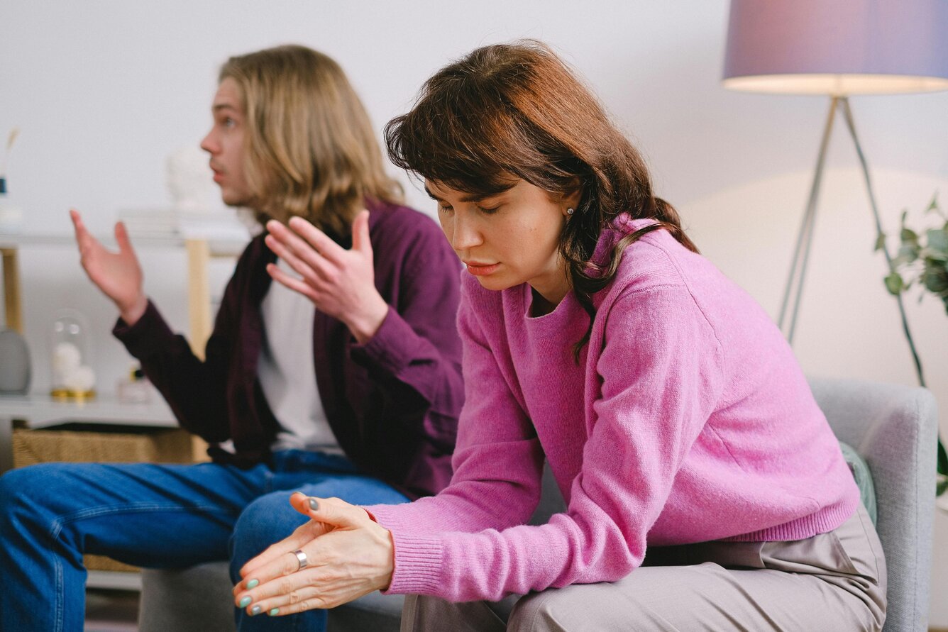 Unhappy man and woman sitting on a couch